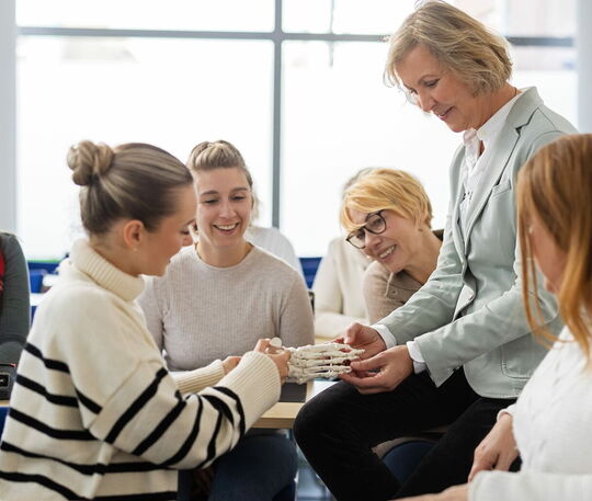 Schülerinnen in der Podologie-Ausbildung lernen die Anatomie des Fusses.